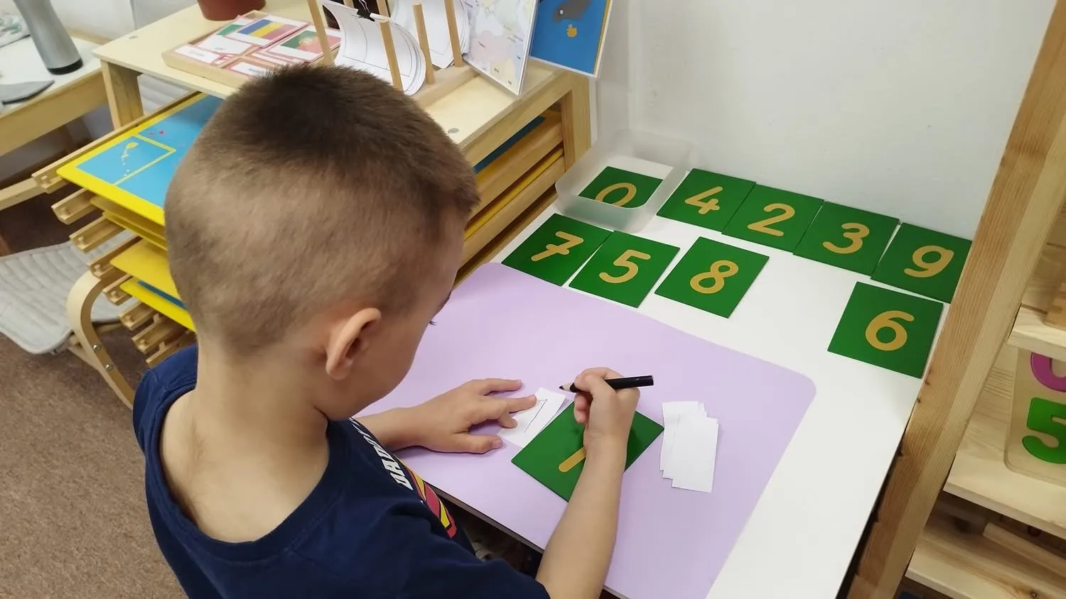 Chlapec pracuje s Montessori materiálom na čísla